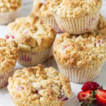 Several baked strawberry rhubarb muffins.