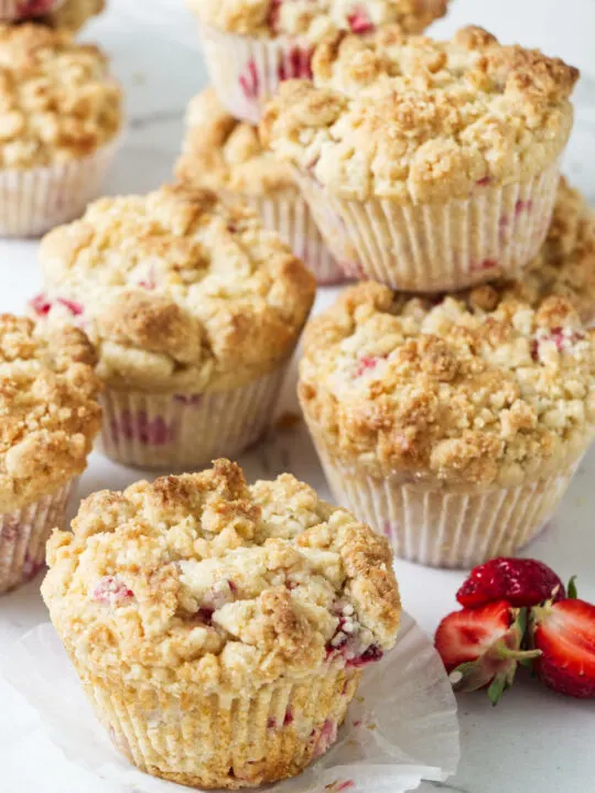 Several baked strawberry rhubarb muffins.