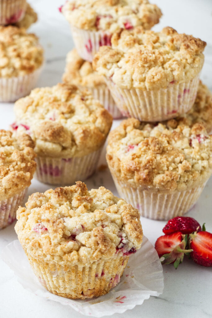 Several baked strawberry rhubarb muffins.