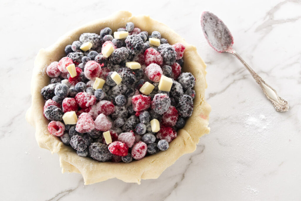 Fresh blackberries, raspberries and blueberries mixed with sugar mixture and dotted with butter.