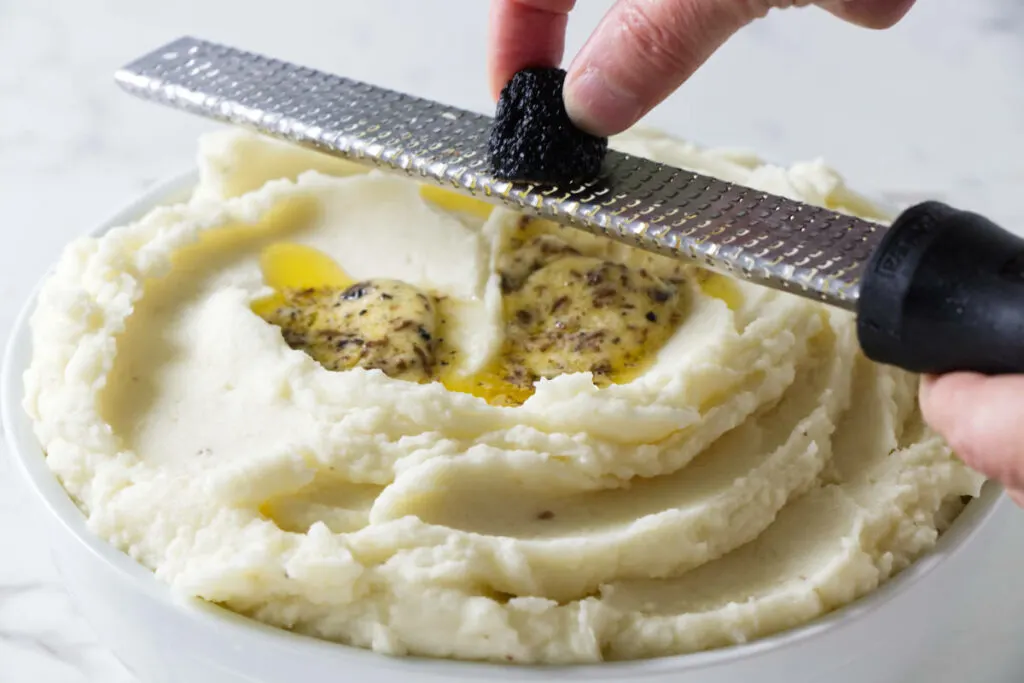 Grating a truffle on mashed potatoes.