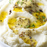 Mashed potatoes with truffle butter melting on top.