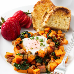 Diced breakfast sweet potatoes on a plate with toast and strawberries.