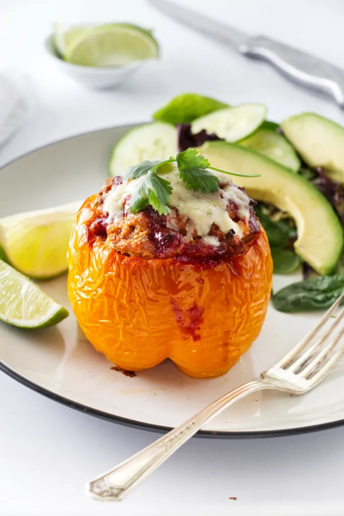 A stuffed bell pepper on a dinner plate.