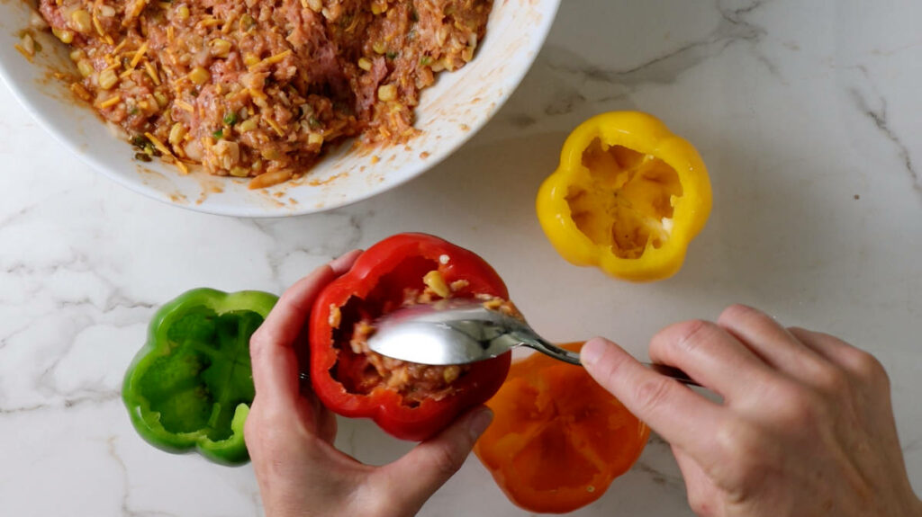 Scooping chicken in a bell pepper.