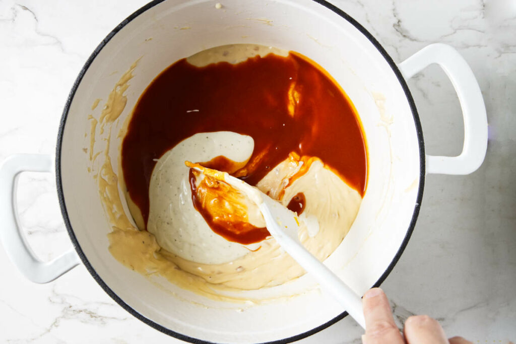 Stirring Buffalo sauce and blue cheese into pasta sauce.