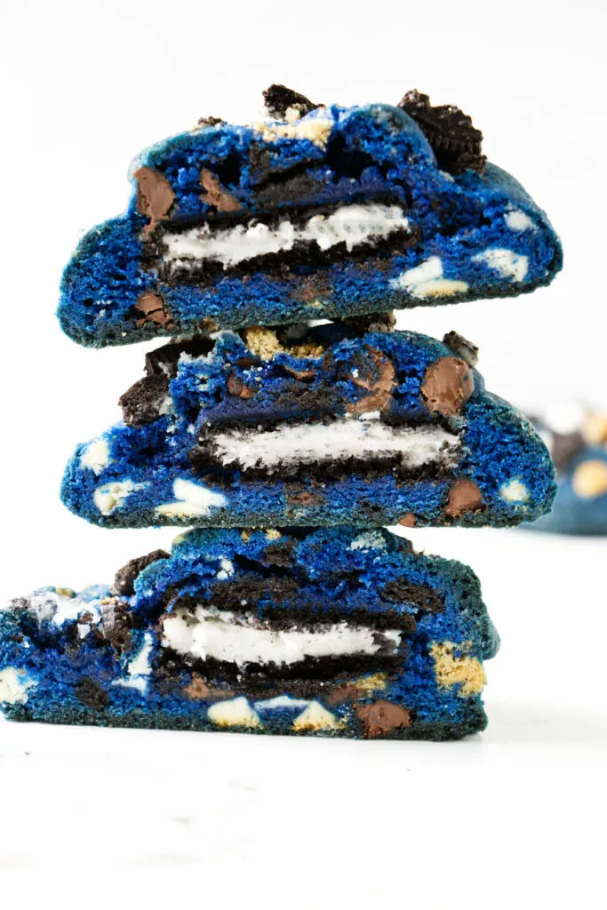 Three cookies stacked on top of each other and cut in half to show Oreo stuffing.