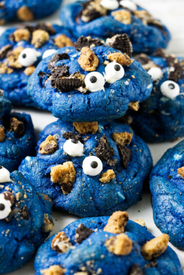 Several blue cookies with candy eyeballs on top.