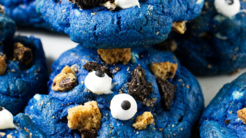 Several blue cookies with candy eyeballs on top.