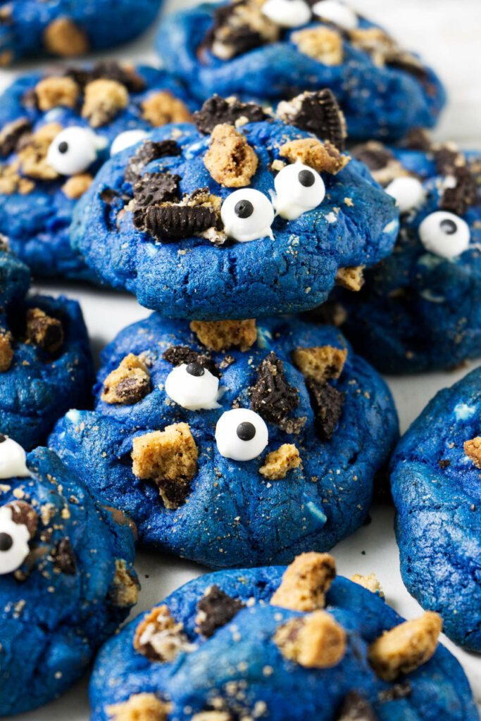 Several blue cookies with candy eyeballs on top.