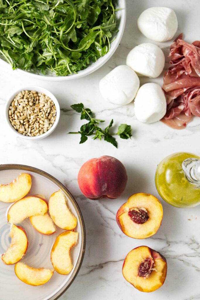 Arugula, burrata, prosciutto, peaches, sunflower seeds, mint leaves, and a vinaigrette.