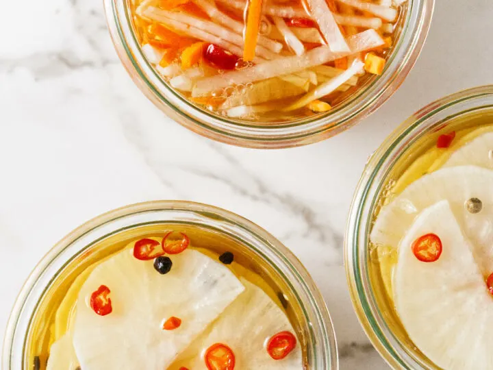 Three jars filled with pickled daikons and carrots.