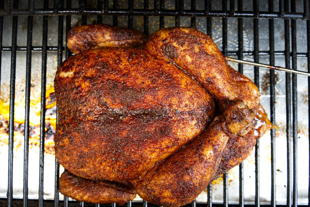 A whole chicken on a pellet grill.