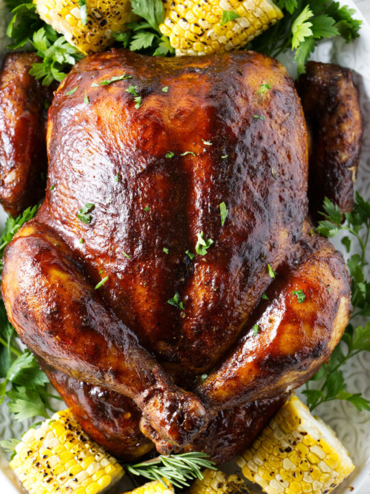 A whole smoked chicken glazed with sauce.