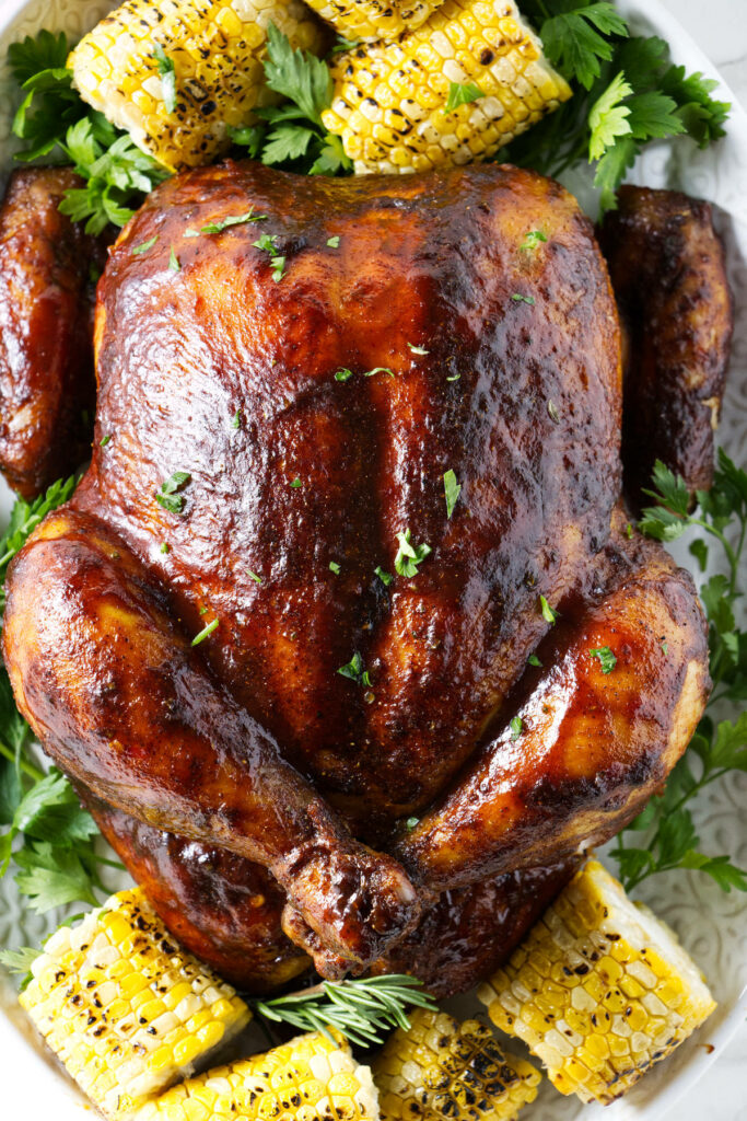 A whole smoked chicken glazed with sauce.