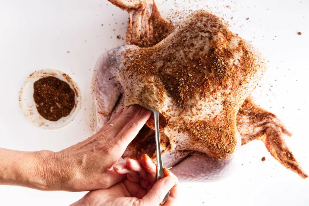 Rubbing Cajun dry rub brine under the skin of the turkey.