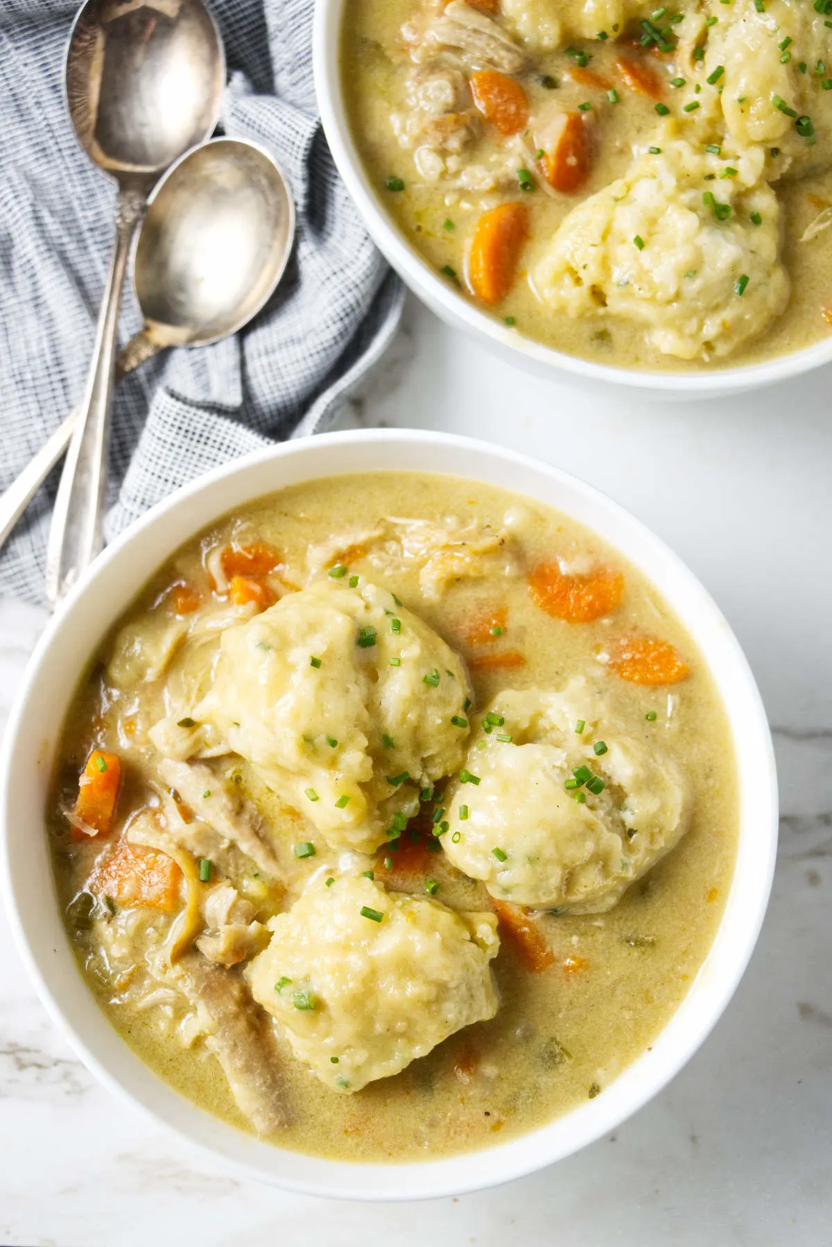 Three large dumplings in a bowl of creamy chicken soup.