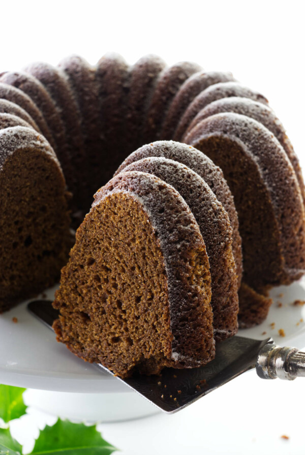 A spatula lifting a slice of gingerbread bundt cake.