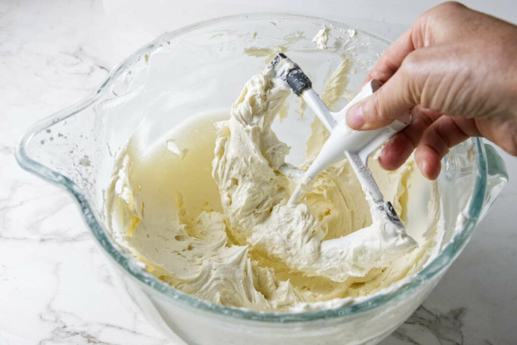 Mixing marshmallow buttercream in a mixing bowl.