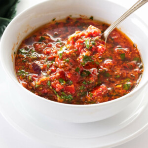 a spoonful of red chimichurri being removed from the bowl