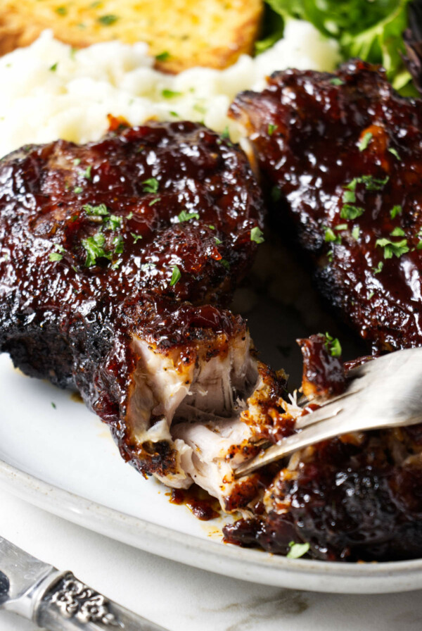 Shredding a pork rib with a fork.