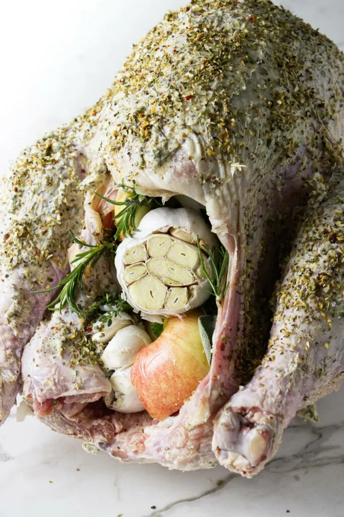 Stuffing the cavity of a turkey with garlic and herbs.