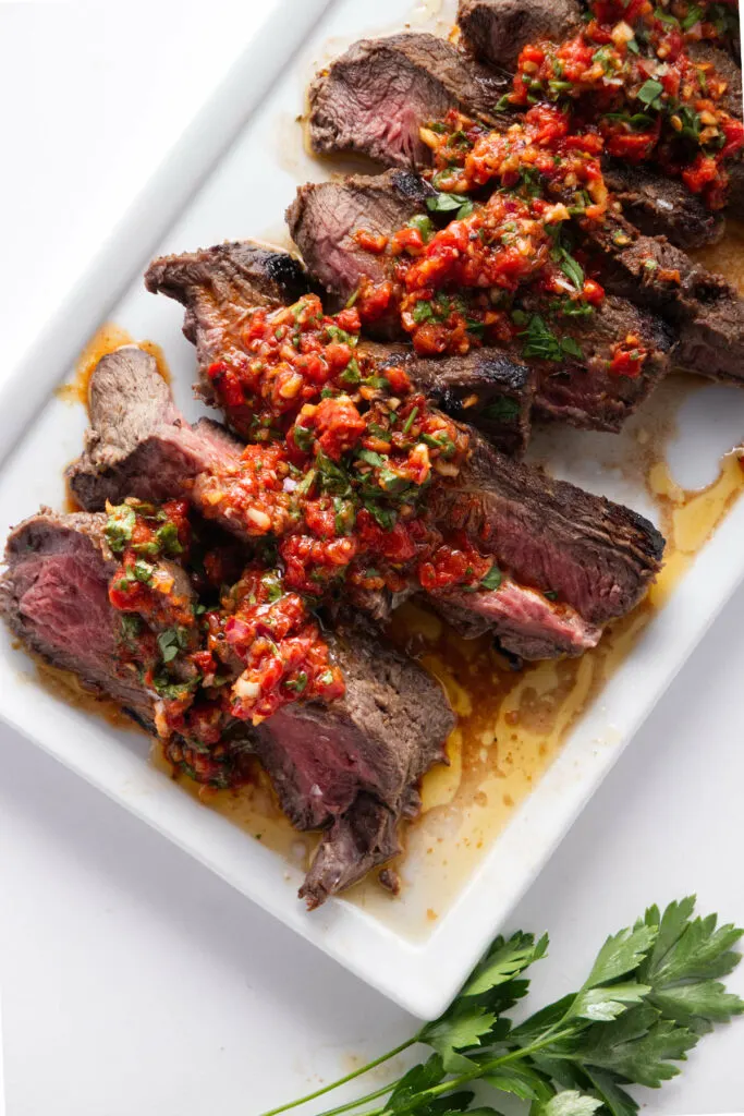 Red chimichurri sauce drizzled on grilled steak