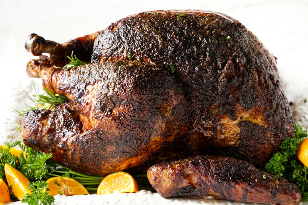 A whole smoked turkey on a large platter.