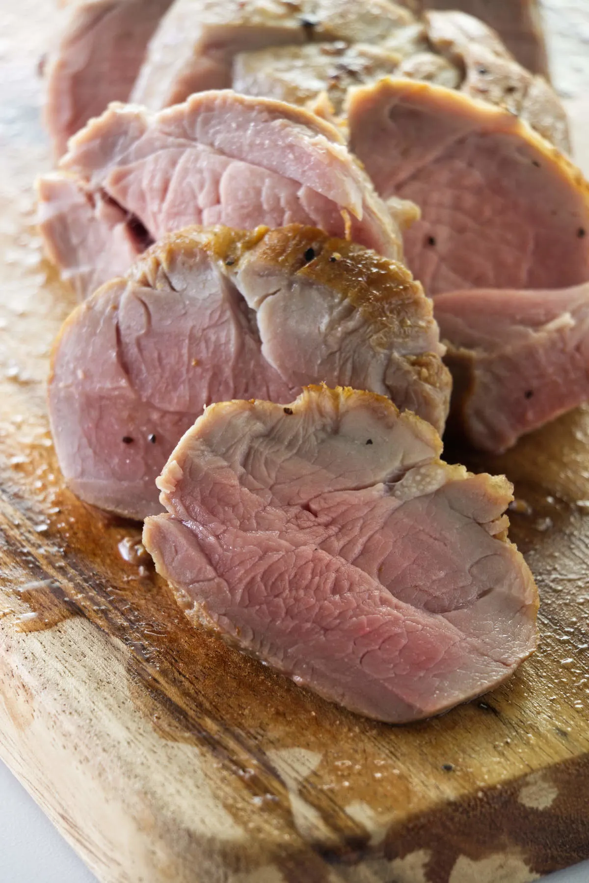 Close up of sous vide pork tenderloin slices on a cutting board