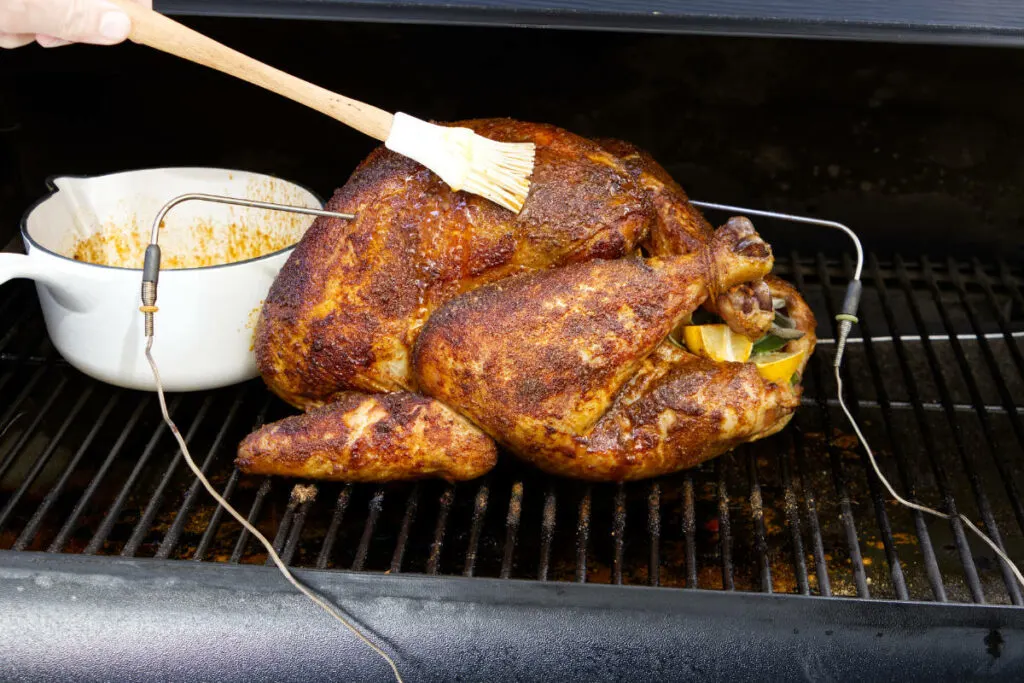 Basting a turkey on the pellet grill.
