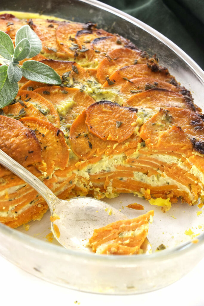 A savory sweet potato casserole with a spoon in the dish.