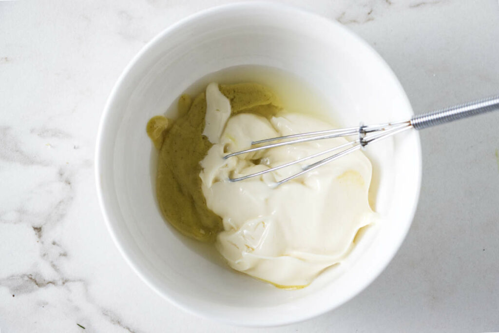 Mixing mayonnaise, mustard, and lemon juice.