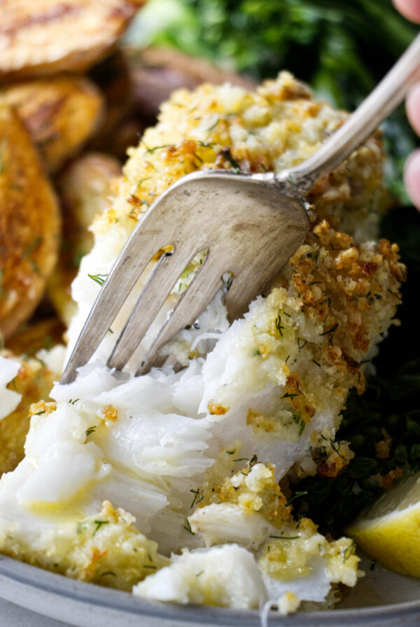 A fork flaking off haddock meat.