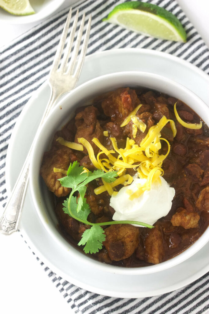 A bowl of chili topped with sour cream and cheese.