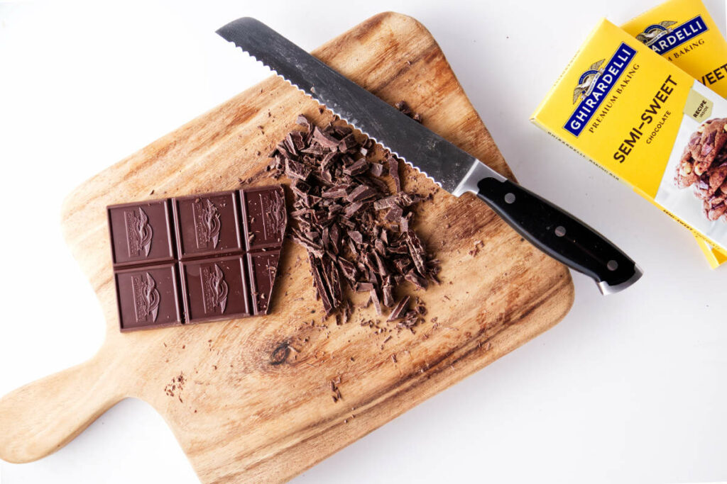 cutting board with chopped chocolate and a knife.