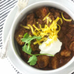 Chili with pork and beans topped with sour cream and cheese.