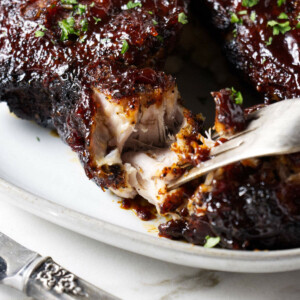 A fork shredding a country style rib.