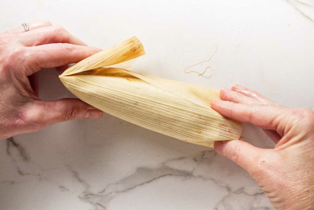 Folding over the end of a corn husk.