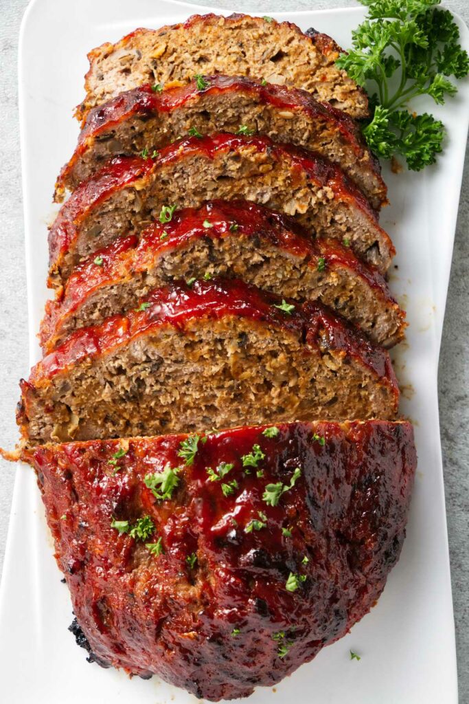 A sliced meatloaf with parsley for garnish.
