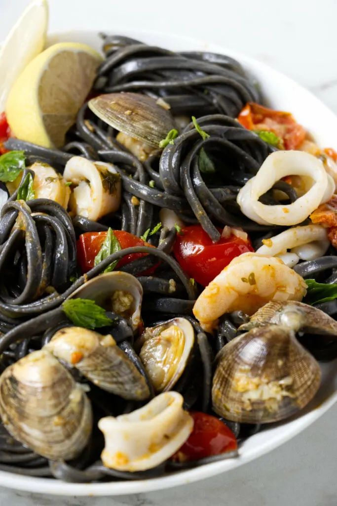 A bowl of black pasta with seafood.