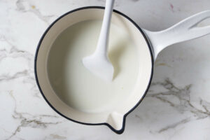 Heating milk and sweetened condensed milk in a saucepan.