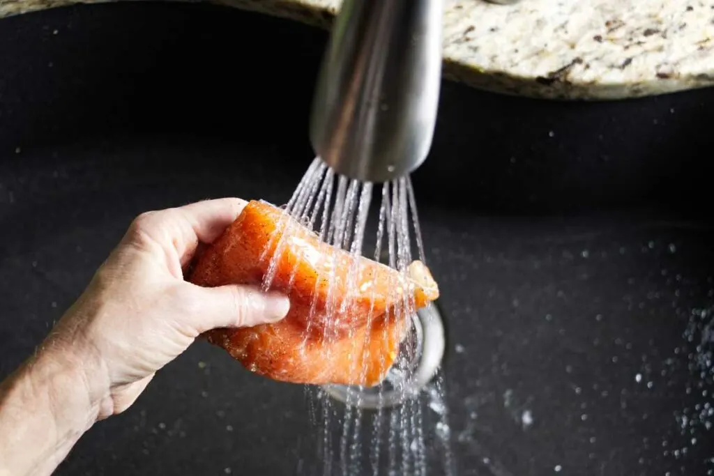 Rinsing the brine off a salmon fillet.
