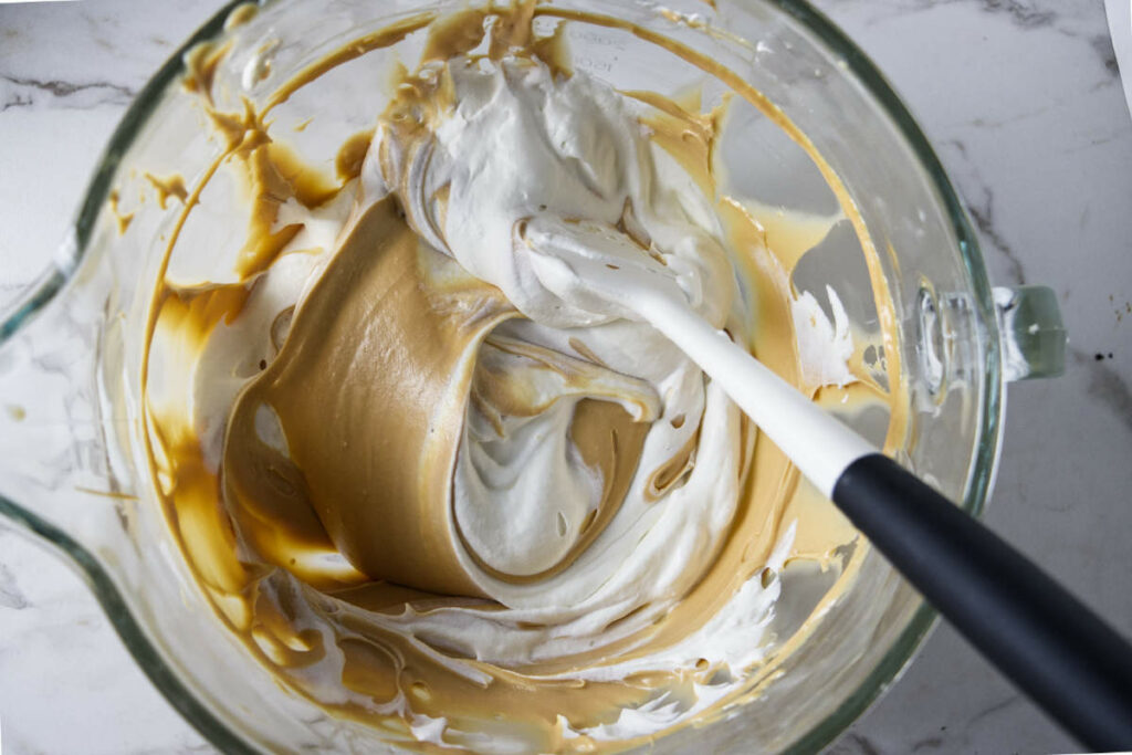Folding whipped cream into the caramel filling.