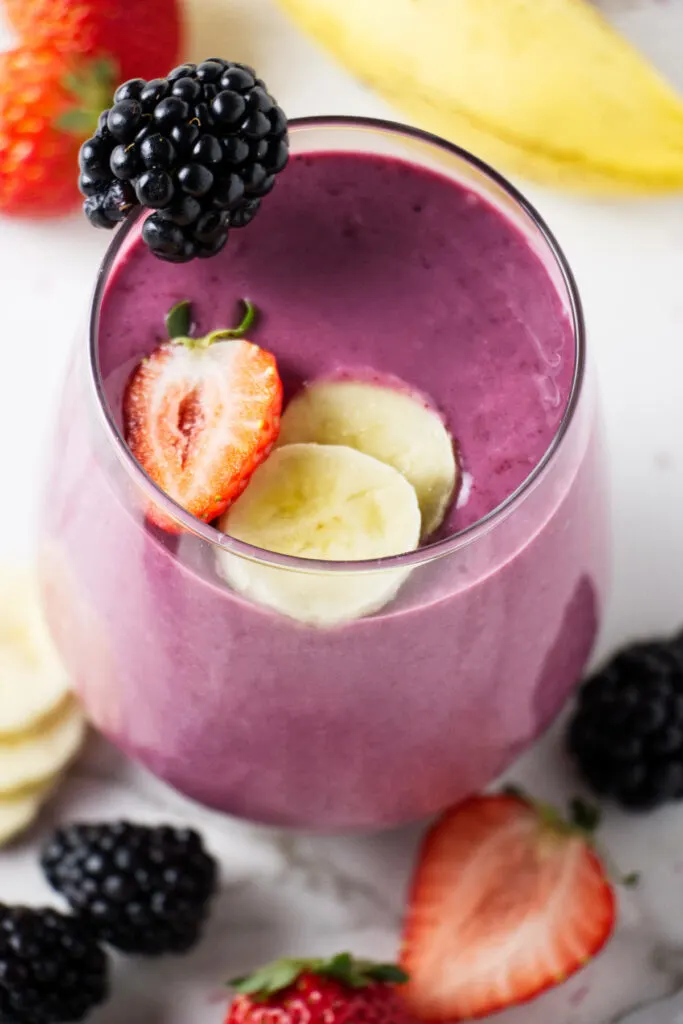 A fruit smoothie in a clear glass.