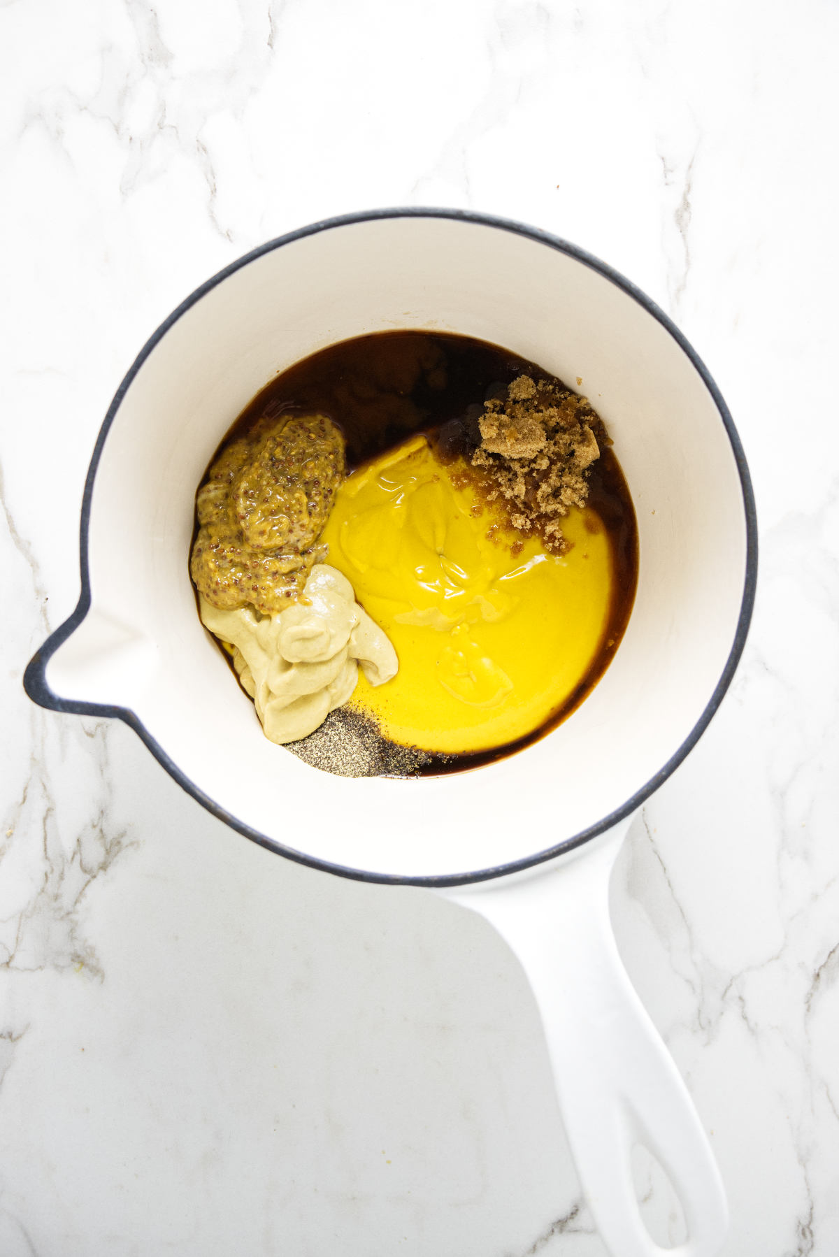 Combining bbq sauce ingredients in a saucepan.