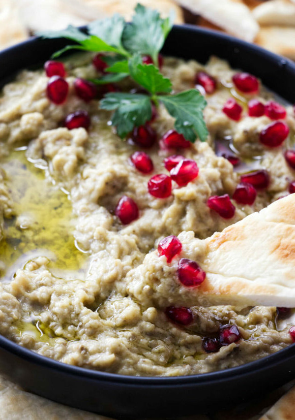 Dipping bread in an eggplant dip.