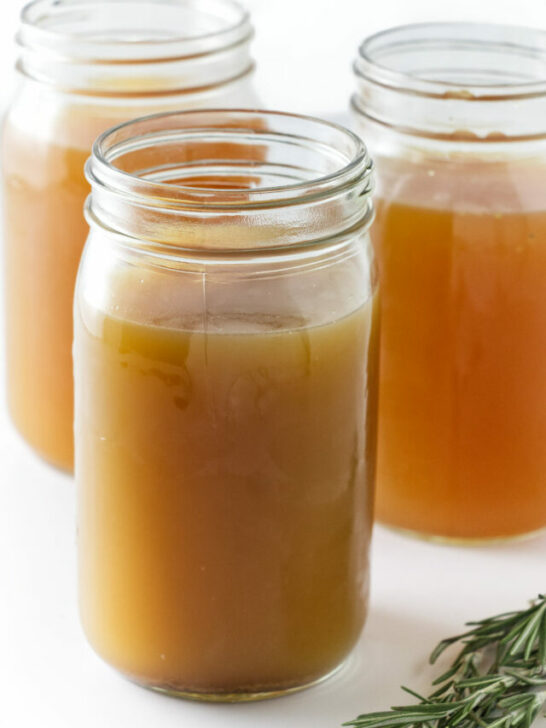 Glass jars filled with homemade chicken bone broth.