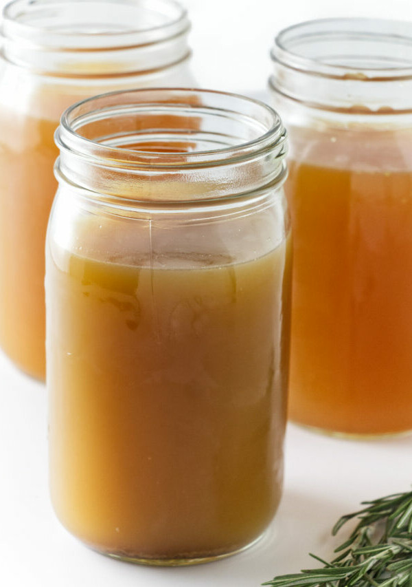 Glass jars filled with homemade chicken bone broth.