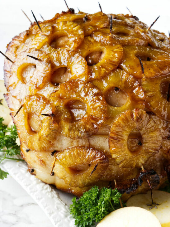 A smoked ham with pineapple rings and glaze.