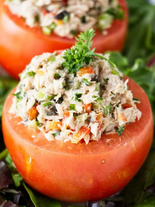 Two tomatoes stuffed with tuna salad.